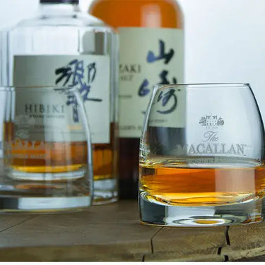 Macallan whisky glass with Japanese whisky bottles on a wooden table, designed for tasting and enhancing flavors.