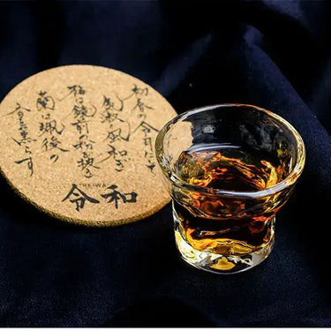 EDO Glass Anniversary Coaster with traditional Japanese design and glass of whiskey on dark background