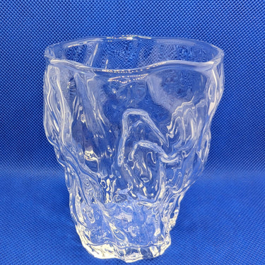 Modern Mout Yong whisky glass with artistic design on blue background.