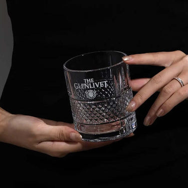 Elegant Glenlivet whisky glass being held, displaying premium lead-free craftsmanship for enhancing whisky's hues and aromas.