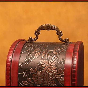 Vintage red wine wooden box with intricate floral carvings and ornate handle.