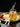 Stainless steel long handle mixing spoons with fruit cocktail and strawberries on a golden tray.