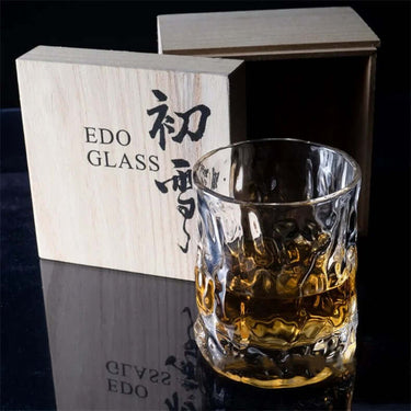 Thick Japanese style whisky glass with intricate hammer design beside Edo Glass wooden box.