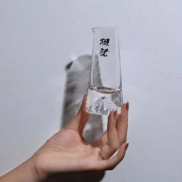 Hand holding Dassai Japanese Traditional Handcrafted Crystal sake glass for cold sake