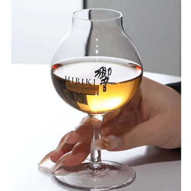 Hand holding Hibiki Professional Blender Whisky Glass with whiskey inside