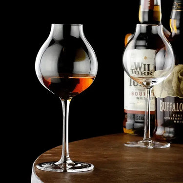 British Blender's Scotch Whisky Tasting Glass with whisky, elegant crystal design on a wooden surface with bottles in the background