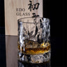 Japanese style hammer crystal whisky glass with unique texture, perfect for savoring spirits, showcased with wooden box background.