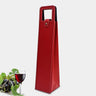 Red wine bottle bag made of faux leather with a handle next to a glass of red wine and grapes.