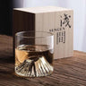 EDO Fuji whisky glass with Mount Fuji design by Liu Siyu, beside Sengen-branded wooden box on a wooden table.