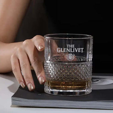 Hand holding Glenlivet Collection lead-free whisky glass with drink