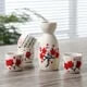 Vintage Ceramic Sake Pot Cups Set with Floral Design on a Wooden Table